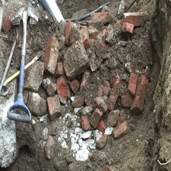 old bricks from old building in a pile with a shovel